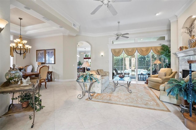 living room featuring ceiling fan with notable chandelier, ornamental molding, a tray ceiling, and light tile patterned flooring