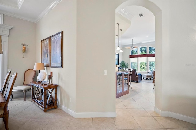 hallway featuring crown molding and light tile patterned floors