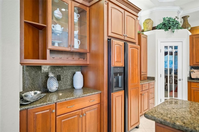 kitchen with fridge with ice dispenser, decorative backsplash, dark stone counters, and crown molding