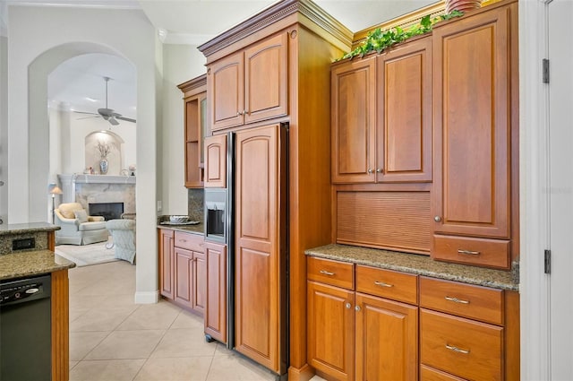 kitchen with paneled refrigerator, a high end fireplace, light stone countertops, ceiling fan, and black dishwasher