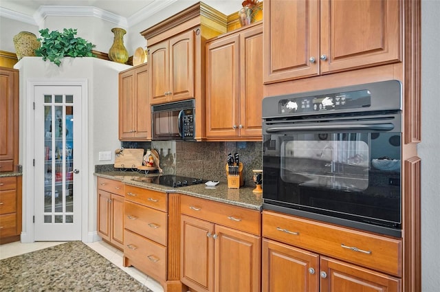 kitchen with dark stone countertops, crown molding, backsplash, black appliances, and light tile patterned flooring