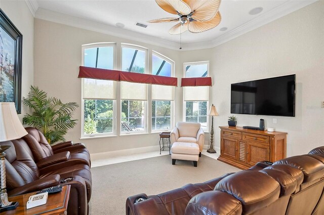 carpeted living room featuring ceiling fan, ornamental molding, and a healthy amount of sunlight