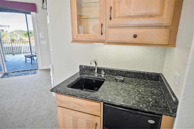 kitchen featuring black dishwasher, carpet, light brown cabinetry, and sink