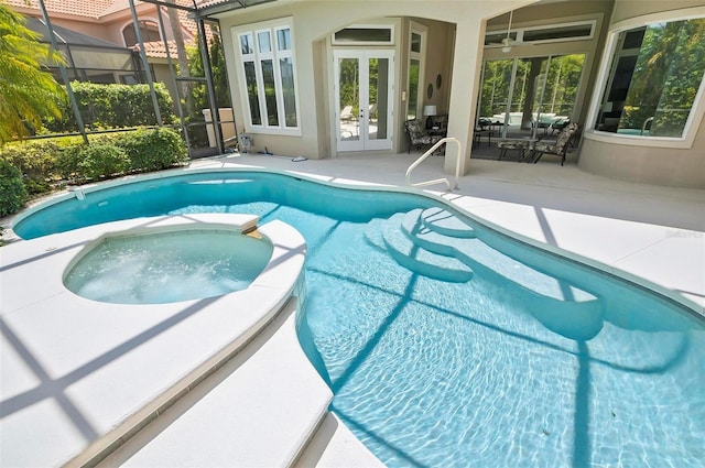 view of swimming pool featuring french doors, a lanai, a patio area, and an in ground hot tub