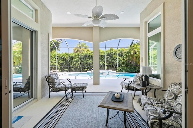 sunroom / solarium with plenty of natural light, a pool, and ceiling fan