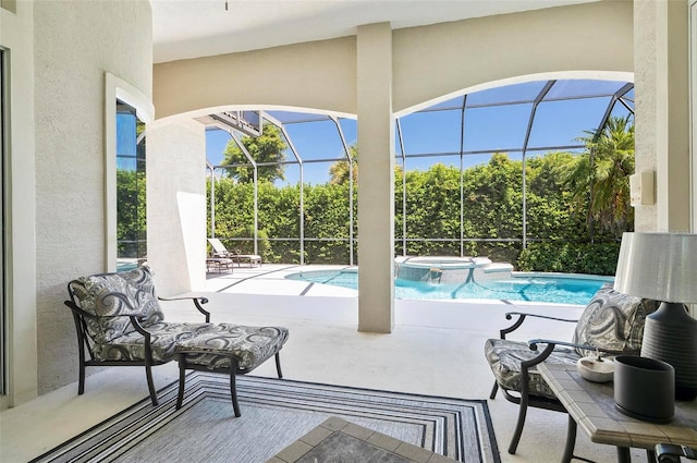 view of pool featuring a lanai, an in ground hot tub, and a patio area