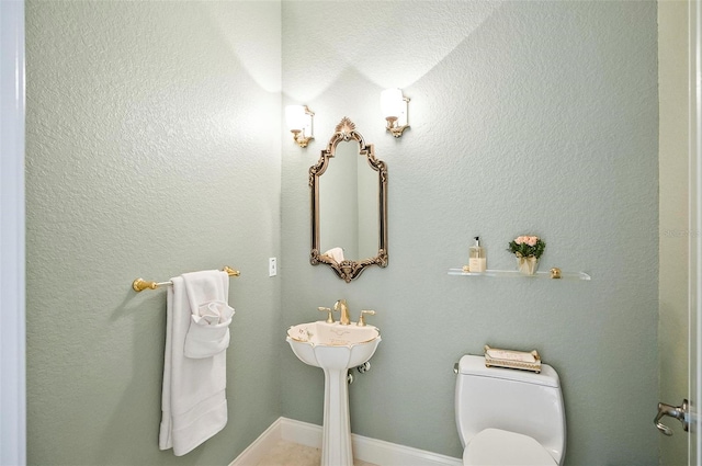 bathroom featuring a textured ceiling and toilet