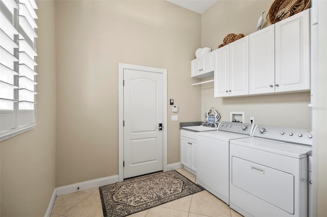 laundry room with washer and clothes dryer, sink, cabinets, and light tile patterned flooring