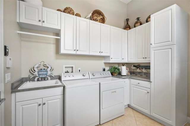 washroom with cabinets, washer and dryer, light tile patterned flooring, and sink