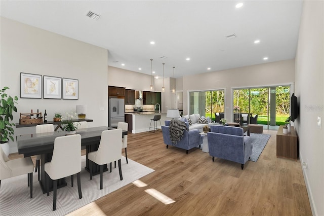 dining space featuring light wood-type flooring and sink