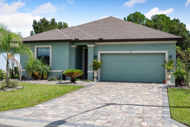 57 Green Cir, Palm Coast, FL 32164 - ranch-style home featuring roof with shingles, stucco siding, a front lawn, an attached garage, and decorative driveway