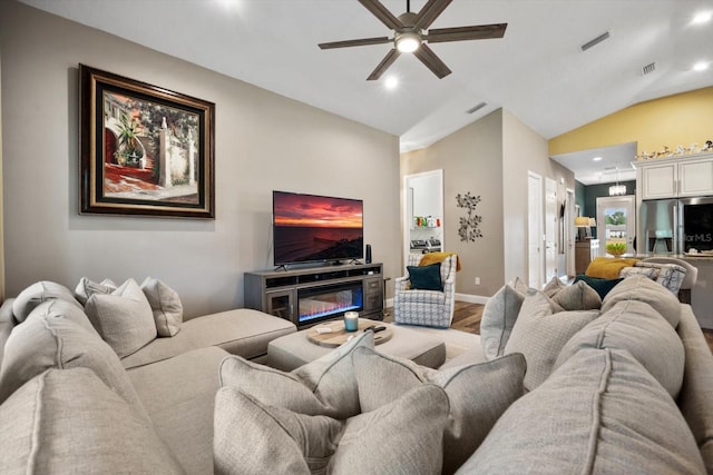 living room with ceiling fan, vaulted ceiling, and wood-type flooring