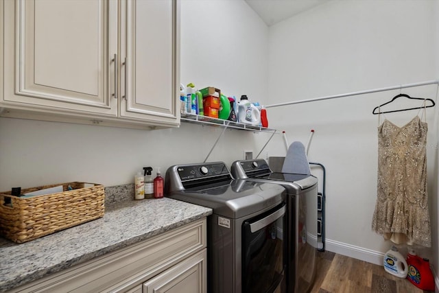 laundry room featuring cabinets, dark wood-type flooring, and washer and dryer