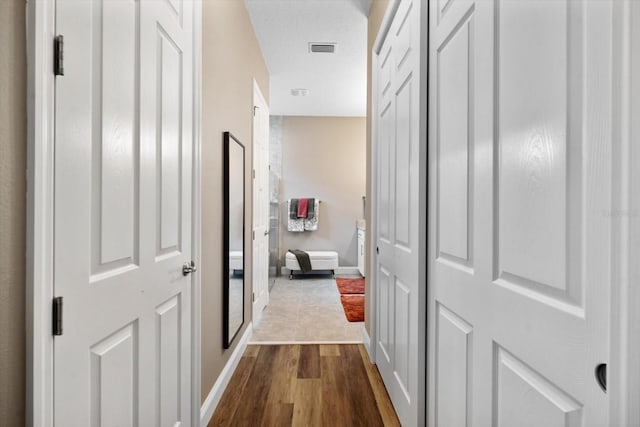 hall featuring a textured ceiling and hardwood / wood-style floors