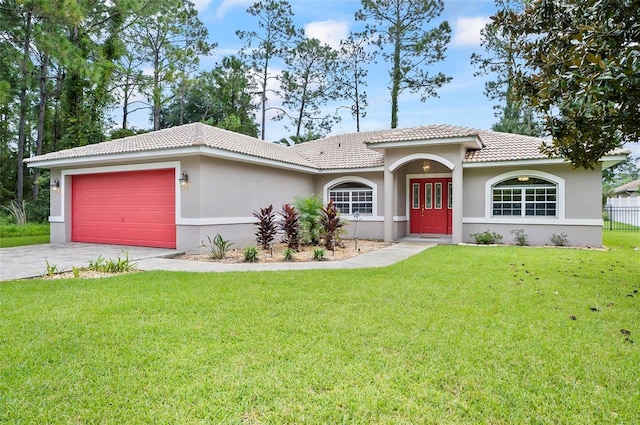 view of front of property with stucco siding, driveway, a front lawn, a garage, and a tiled roof