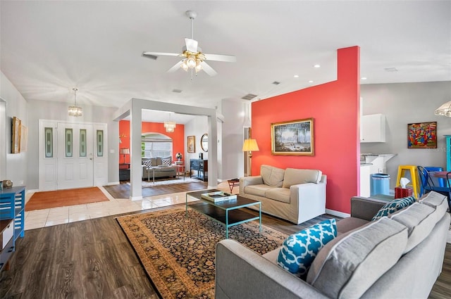 living room featuring light hardwood / wood-style flooring and ceiling fan with notable chandelier