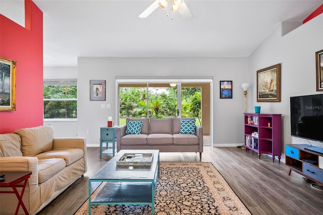 living room featuring ceiling fan, dark hardwood / wood-style floors, and vaulted ceiling