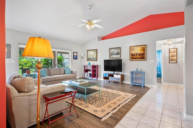 living room with ceiling fan, light tile patterned floors, and vaulted ceiling