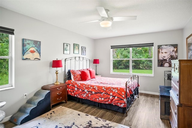 bedroom with multiple windows, ceiling fan, and dark hardwood / wood-style floors