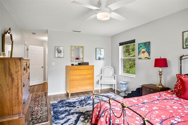 bedroom featuring a textured ceiling, hardwood / wood-style flooring, and ceiling fan