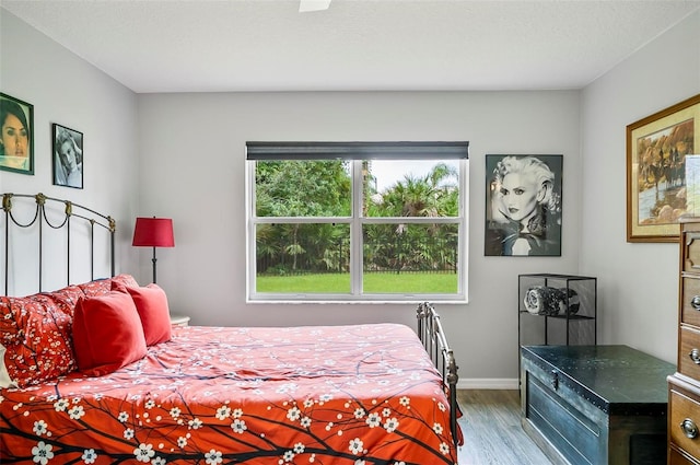 bedroom with a textured ceiling and wood-type flooring