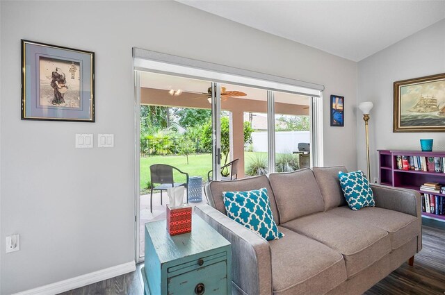 living room featuring lofted ceiling, dark wood-type flooring, and ceiling fan