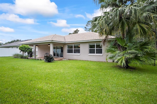 back of house with a lawn and a patio