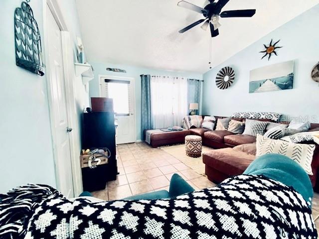 living room with ceiling fan and light tile patterned floors