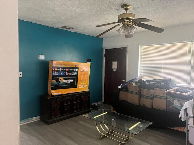 living room with ceiling fan, hardwood / wood-style flooring, and a textured ceiling