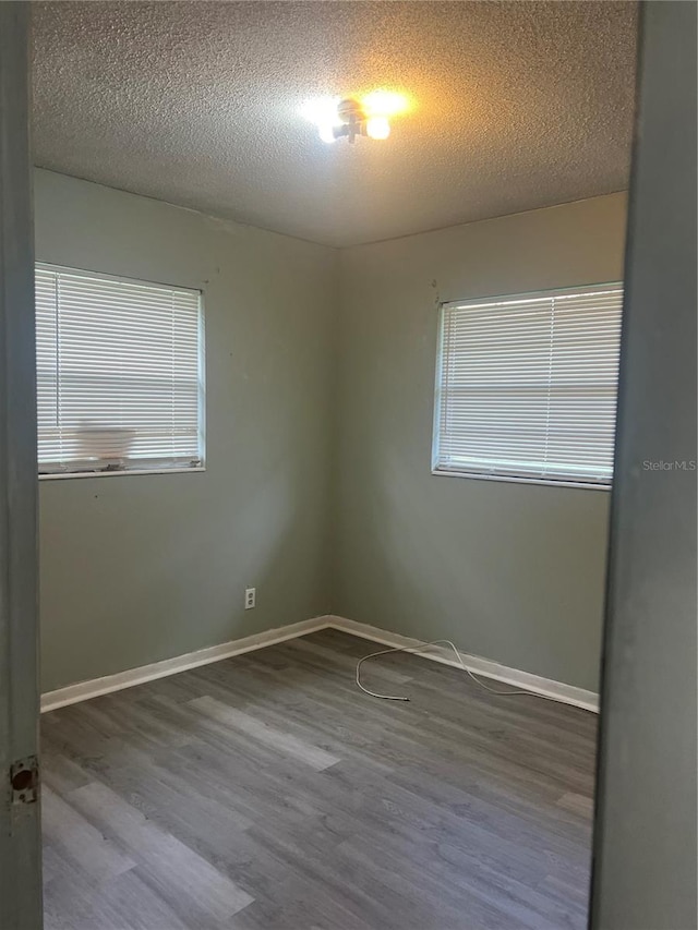 empty room with a textured ceiling and hardwood / wood-style floors