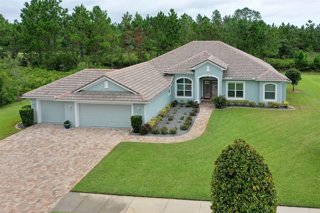 ranch-style home featuring a garage and a front lawn