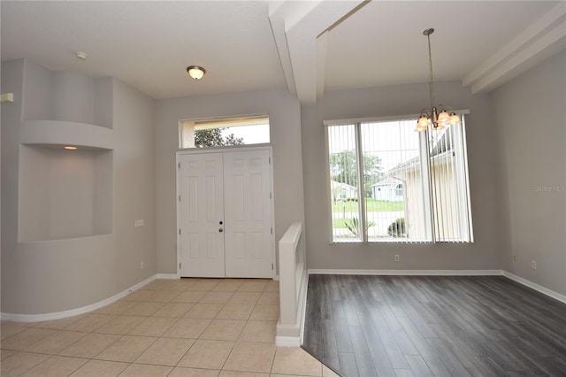 entrance foyer with a chandelier, beam ceiling, and light hardwood / wood-style floors