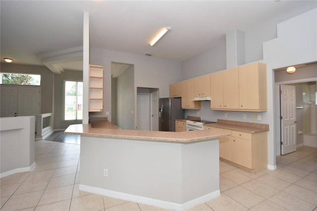 kitchen with light brown cabinetry, light tile patterned floors, stainless steel fridge, white range, and kitchen peninsula