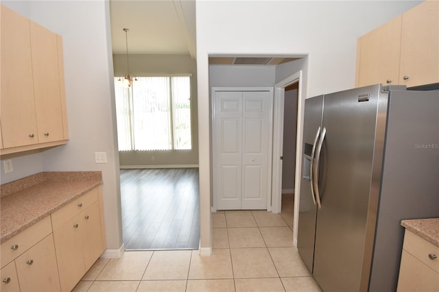 kitchen with light hardwood / wood-style flooring, stainless steel fridge, and hanging light fixtures