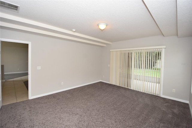 carpeted empty room featuring a textured ceiling