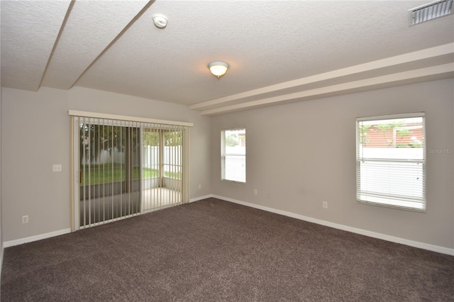 unfurnished room featuring a textured ceiling and dark colored carpet