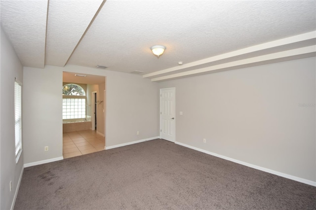 carpeted empty room featuring a textured ceiling