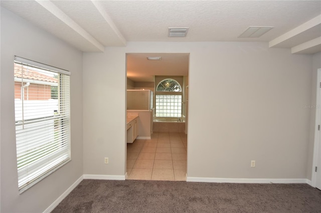 carpeted empty room featuring a textured ceiling