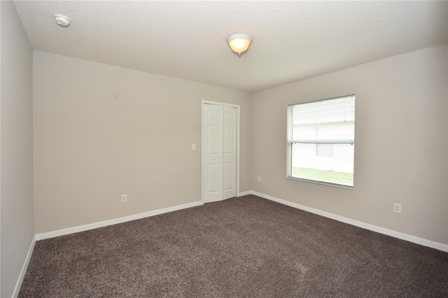 carpeted spare room featuring a textured ceiling