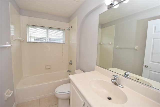 full bathroom with tiled shower / bath, vanity, toilet, and tile patterned floors