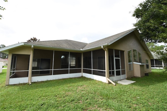 back of house featuring a yard and a sunroom