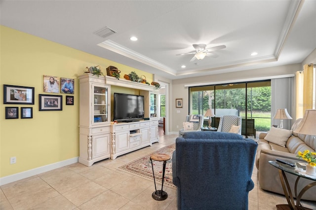 tiled living room with ornamental molding, a raised ceiling, and ceiling fan