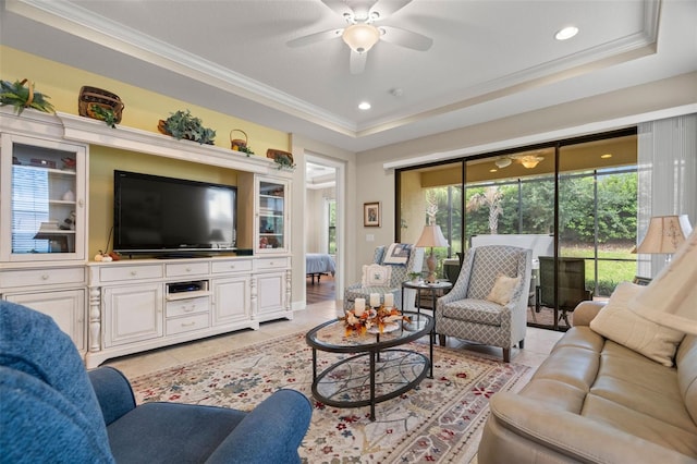 tiled living room with crown molding, a raised ceiling, and ceiling fan