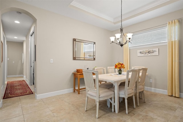 tiled dining space featuring crown molding, a notable chandelier, and a raised ceiling