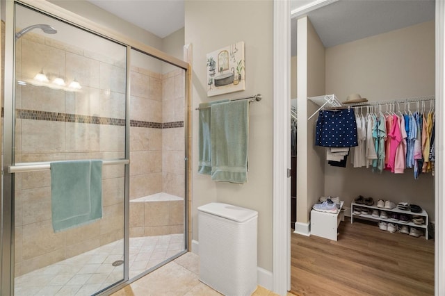 bathroom with wood-type flooring and a shower with shower door