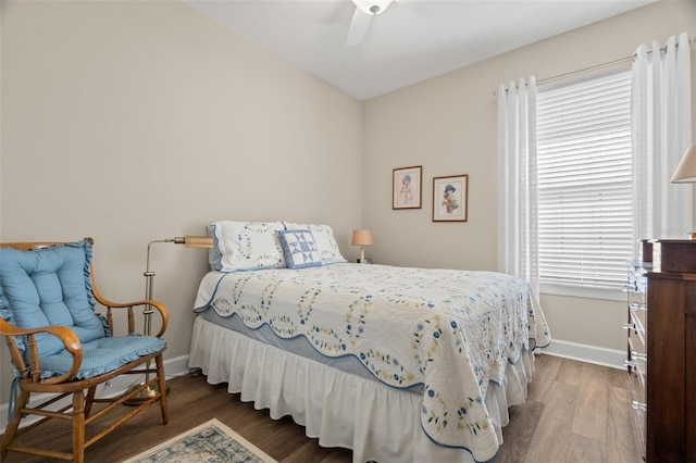 bedroom with multiple windows, hardwood / wood-style floors, and ceiling fan