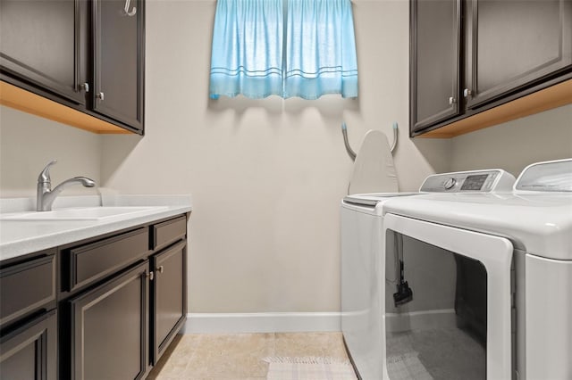 laundry area featuring cabinets, light tile patterned flooring, sink, and separate washer and dryer