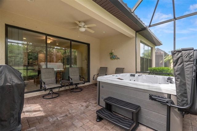 view of patio featuring a hot tub, a lanai, ceiling fan, and grilling area