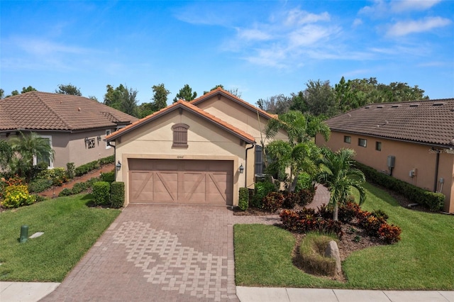 mediterranean / spanish home featuring a front yard and a garage