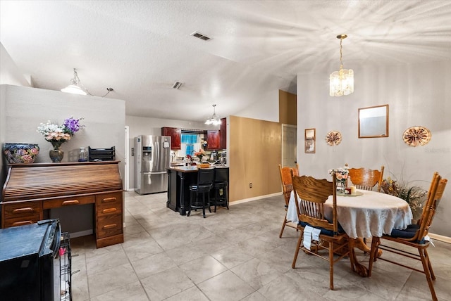 dining area featuring an inviting chandelier and vaulted ceiling